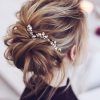 Wavy Low Bun Bridal Hairstyles With Hair Accessory (Photo 8 of 25)