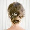 Wavy Low Bun Bridal Hairstyles With Hair Accessory (Photo 6 of 25)